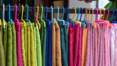 Canlı eşarplar bir askıda asılı moda ve pazarla ilgili tasarımlar için mükemmel renkler yaratıyor.