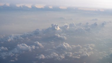Uçsuz bucaksız beyaz bulutlar gökyüzünü dolduruyor seyahat veya arka plan kullanımı için uygun sakinleştirici bir atmosfer yaratıyor.