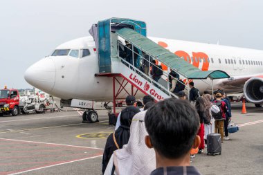 Jakarta, 6 Nisan 2024: Yolcu kuyruğuyla birlikte Soekarno Hatta Havalimanı 'nda bekleyen yolcu uçağı