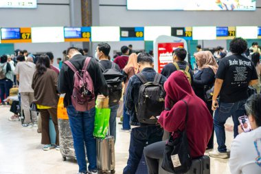 Jakarta, 6 Nisan 2024: Soekarno Hatta Havalimanı Kontratında Sırt çantalı ve Sırt çantalı Yolcular kuyruğu