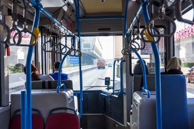 Jakarta, Endonezya 'daki bir otobüsün içerisi yolcuları gösteriyor, mavi tırabzanlar ve dışarıdaki otoyol trafiği, seyahat ve kentsel sahne kullanımı için harika.