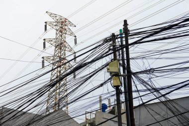Karışık elektrik kabloları, altyapı veya kentsel meydan okumalar için uygun bir güç kulesi ve elektrik direklerinin üzerinde dağınık bir ağ oluşturur..