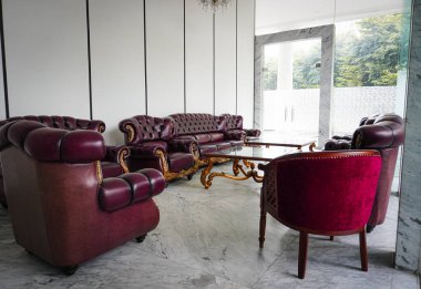 Parlak bir lobiye yerleştirilmiş lüks bordo deri kanepe mermer zeminli zarif bir atmosfer yaratır. İç dizayn için harika bir ilham kaynağı..
