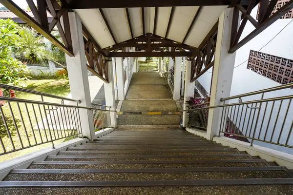 Çelik korkuluklar ve peyzaj bahçesiyle kaplı bir merdivenden aşağıya bakmak, mimari veya seyahat içeriği için mükemmel bir iniş hissi sunar..