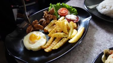 Ağır çekimde akşam yemeği: Kızarmış köfte, patates ve güneşli yumurta.