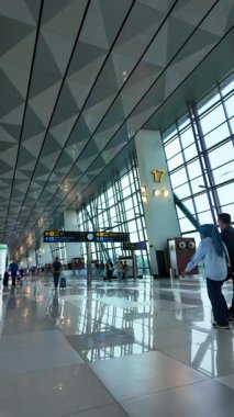Jakarta, 5 Ağustos 2025: Camdan Duvarlar ve Yansımalarla Bir Havalimanı Terminalinde Yürüyen Yolcuların Yavaş Çekimi