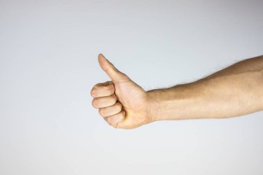 Beyaz arka planda baş parmağını gösteren bir elin yakın plan çekimini yakından çek. Beyaz arkaplanda baş parmağını gösteren bir el.