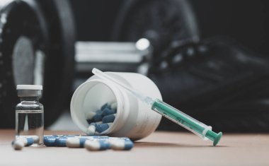 Dambıllar, şırınga, şişe ve steroidli haplar. Spor konseptinde yasadışı doping