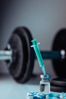 Dambıllar, şırınga, şişe ve steroidli haplar. Spor konseptinde yasadışı doping