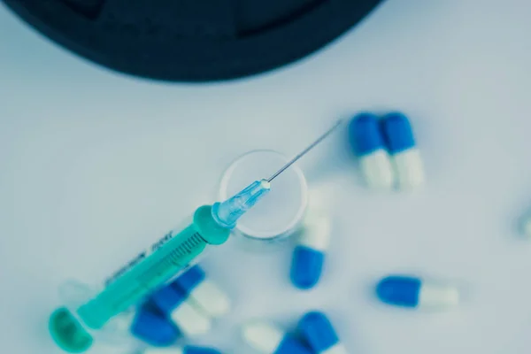 Dambıllar, iğneli şırınga, haplar ve steroidli şişe. Spor konseptinde yasadışı doping
