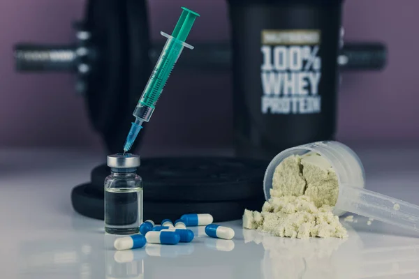 dumbbell, syringe with needle, pills, vial with steroids and whey powder in scoop. illegal doping in sport concept. loss weigh or build muscle.