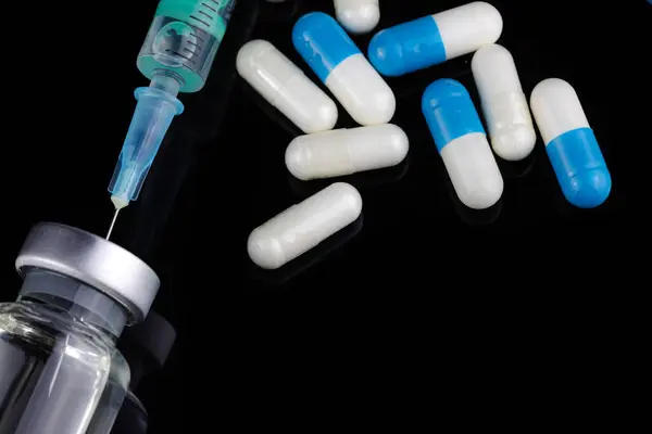 İğneli şırınga, haplar ve steroidli şişe. Spor konseptinde yasadışı doping. Şişeler ve Uyuşturucu Ampülü