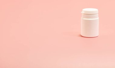 Pembe arka planda beyaz plastik şişe. Boşluğu kopyala 