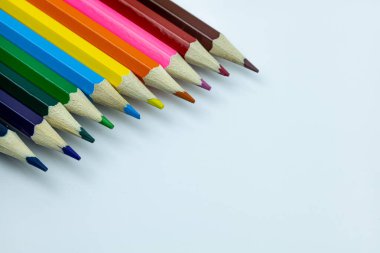 Beyaz arkaplanda renkli kalemler, metin için boşluk olan üst görünüm