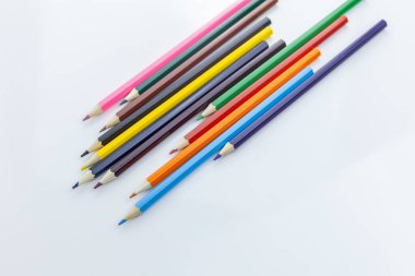 Beyaz arkaplanda renkli kalemler, metin için boşluk olan üst görünüm