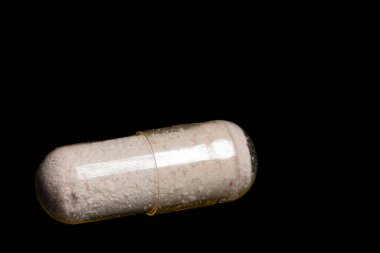 Siyah arka planda beyaz kapsülü kapat. makro fotoğraf 