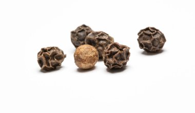 Bir yığın karabiber ve karabiber. makro fotoğraf. Beyaz arkaplanda ön görünüm