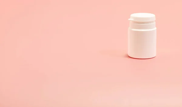 Pembe arka planda beyaz plastik şişe. Boşluğu kopyala 