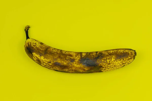 stock image ripe, rotten banana on yellow background 