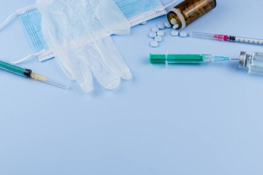 Beyaz koruyucu eldiven, tıbbi maske, iğneli şırınga, aşı şişesi ve haplar. Spor konseptinde yasadışı doping, grip aşısı, uyuşturucu bağımlısı, ıslak tıp. tıbbi öge arkaplanı