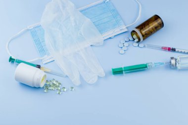 Beyaz koruyucu eldiven, tıbbi maske, iğneli şırınga, aşı şişesi ve haplar. Spor konseptinde yasadışı doping, grip aşısı, uyuşturucu bağımlısı, ıslak tıp. tıbbi öge arkaplanı