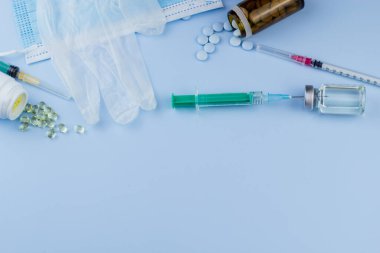 Beyaz koruyucu eldiven, tıbbi maske, iğneli şırınga, aşı şişesi ve haplar. Spor konseptinde yasadışı doping, grip aşısı, uyuşturucu bağımlısı, ıslak tıp. tıbbi öge arkaplanı