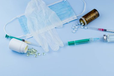Beyaz koruyucu eldiven, tıbbi maske, iğneli şırınga, aşı şişesi ve haplar. Spor konseptinde yasadışı doping, grip aşısı, uyuşturucu bağımlısı, ıslak tıp. tıbbi öge arkaplanı