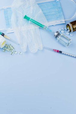Beyaz koruyucu eldiven, tıbbi maske, iğneli şırınga, aşı şişesi ve haplar. Spor konseptinde yasadışı doping, grip aşısı, uyuşturucu bağımlısı, ıslak tıp. tıbbi öge arkaplanı