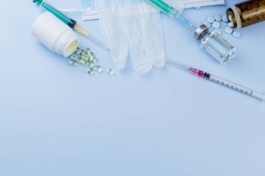 Beyaz koruyucu eldiven, tıbbi maske, iğneli şırınga, aşı şişesi ve haplar. Spor konseptinde yasadışı doping, grip aşısı, uyuşturucu bağımlısı, ıslak tıp. tıbbi öge arkaplanı