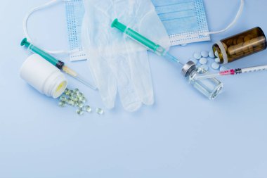 Beyaz koruyucu eldiven, tıbbi maske, iğneli şırınga, aşı şişesi ve haplar. Spor konseptinde yasadışı doping, grip aşısı, uyuşturucu bağımlısı, ıslak tıp. tıbbi öge arkaplanı