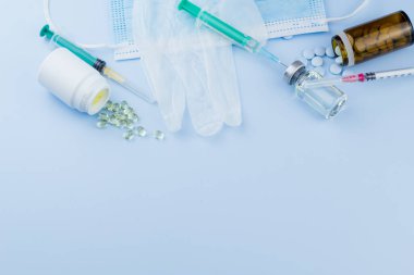 Beyaz koruyucu eldiven, tıbbi maske, iğneli şırınga, aşı şişesi ve haplar. Spor konseptinde yasadışı doping, grip aşısı, uyuşturucu bağımlısı, ıslak tıp. tıbbi öge arkaplanı