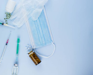 Beyaz koruyucu eldiven, tıbbi maske, iğneli şırınga, aşı şişesi ve haplar. Spor konseptinde yasadışı doping, grip aşısı, uyuşturucu bağımlısı, ıslak tıp. tıbbi öge arkaplanı