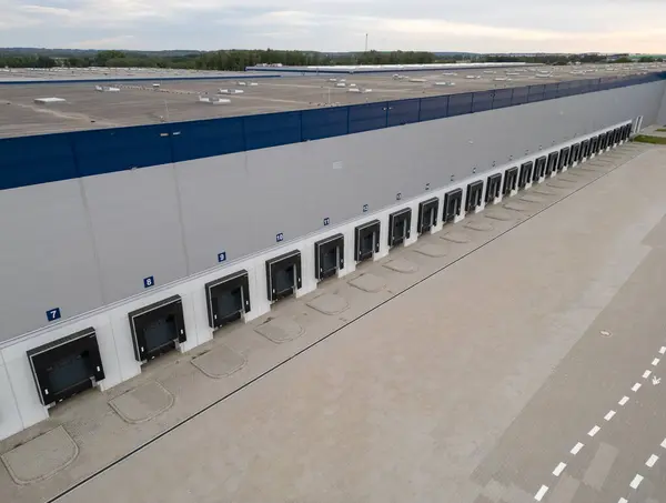 Hangarları ve kamyonları olan depo binasının hava aracı görüntüsü