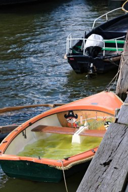 içinde çocuk resmi olan turuncu tekne.