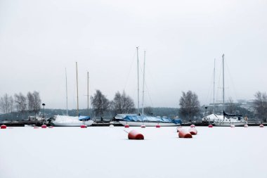 Laid up sailboats in ice covered harbor at the Baltic Sea for winter lay-up concept