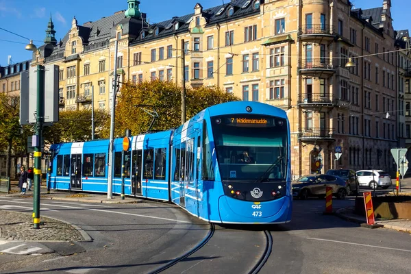 SL Storstockholms Lokaltrafik blue modern tram on Strandvagen at Ostermalm in the autumn for commuting and public transport concept