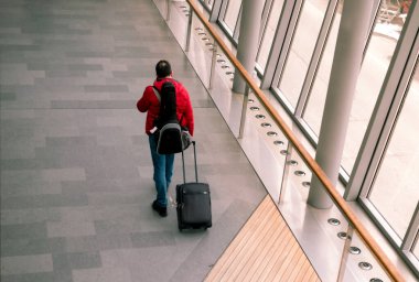 Modern havaalanında tekerlekli çantalı Singel gezgini.
