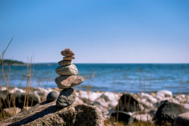 Meditasyon, zen, sükunet ve iş hayatı dengesi konsepti için plajda uyum içinde istiflenmiş taşlar.