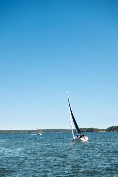 stock image Sailboat with black sails on adventurous sailing holiday in picturesque archipelago landscape by the coast in Sweden, Scandinavia