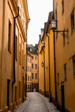Stockholm 'ün tarihi dar sokaklarında ortaçağ sarı taş evleri. Bollhusgrand Caddesi' ndeki Gamla Stan kasabası.