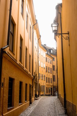 Stockholm 'ün tarihi dar sokaklarında ortaçağ sarı taş evleri. Bollhusgrand Caddesi' ndeki Gamla Stan kasabası.