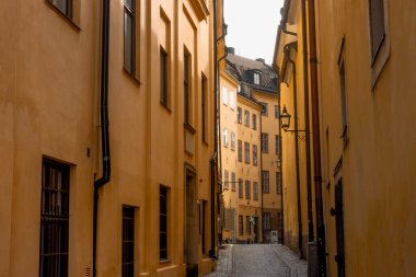 Stockholm 'ün tarihi dar sokaklarında ortaçağ sarı taş evleri. Bollhusgrand Caddesi' ndeki Gamla Stan kasabası.