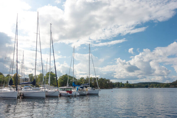 Small boat marina with sailboats and motorboats moored in summer by Gustavsberg harbor in Sweden in Stockholm archipelago