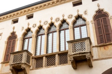 Palazzo Magnavin-Foratti 'nin beyaz Venedik tarzı ortaçağ taş binasının ön cephesi. Montagnana' nın eski pitoresk kasabasının dekoratif pencereleri. 