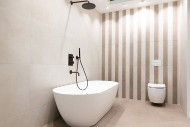 Şık ve lüks banyo tasarımı, büyük gri taş fayanslar, seramik küvet ve modern iç tasarım konsepti için modern tuvalet. 