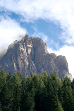 Sassolungo, Langkofel dağı, Dolomitler 'deki İtalyan Alpleri öğleden sonra, güneş yamaçlarına vururken ve bulutlar kayalık yüzeyinde şekillenirken.