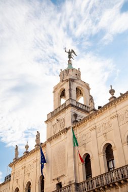 Ornate facade of Palazzo Moroni, the town hall of Padova, Italy, against blue sky in summer, with Italian and EU flags