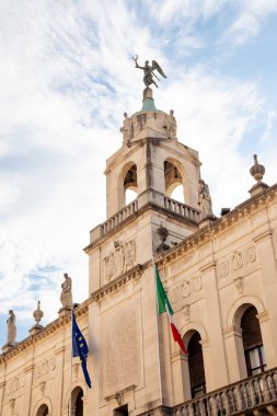 Ornate facade of Palazzo Moroni, the town hall of Padova, Italy, against blue sky in summer, with Italian and EU flags