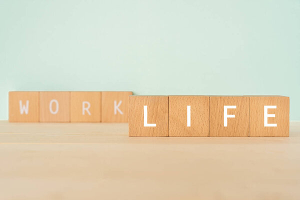 LIFE, Work-life balance; Wooden blocks with "LIFE" text of concept.