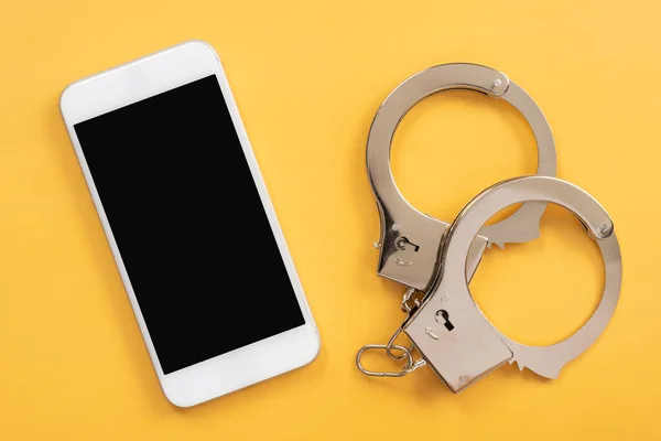 Handcuffs Mobile Phone Yellow Background — ストック写真